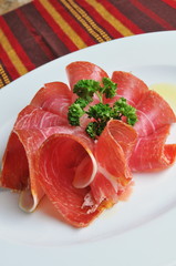 Slices of Italian ham prosciutto on a plate
