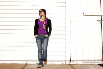 Casually leans on building.