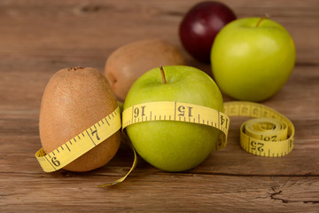 Diet concept, kiwi fruit with green apple and measuring tape on