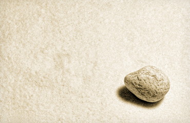 Fototapeta na wymiar Runder Stein auf Sand Antikstyle
