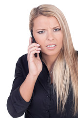Worried young blond woman talking on mobile phone