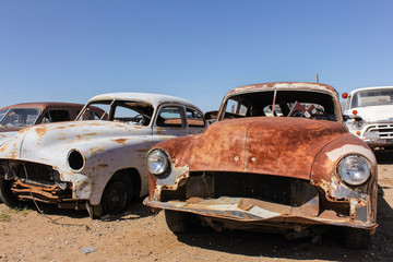 Obraz na płótnie Canvas Widok z przodu starych zardzewiałych samochodów