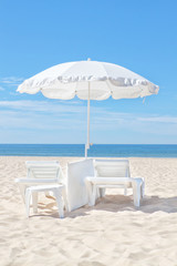 Beautiful white beach umbrella on a sunny beach. For the rest.