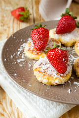 cheesecakes with powdered sugar and a strawberry on top