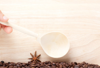 coffee beans on wooden surface with wooden spoon