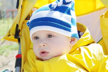 portrait of nice baby outdoors in yellow jacket