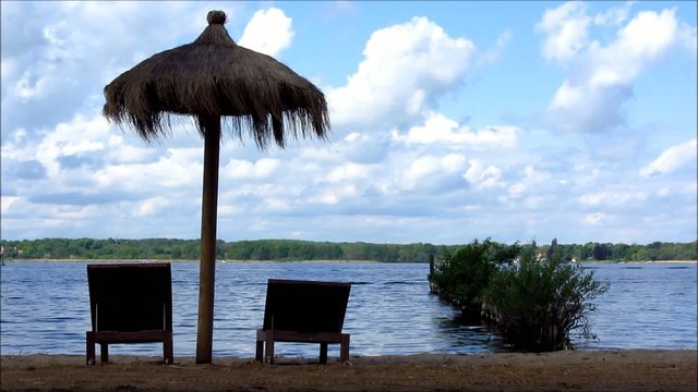 Wooden deckchairs and parasol on the beach