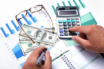 Hand with calculator and money.