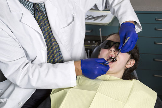 Dentist doing examination on teeth on young girl