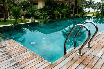 Small swimming pool with wooden setting surrounded by trees