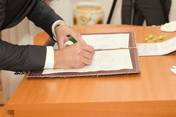 Groom Signing Marriage Certificate - obrazy, fototapety, plakaty