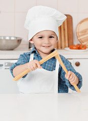 little boy holding a spaghetti cook in the hands of