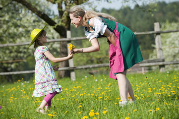 Fototapeta premium Mädchen bringt Mutter Blumen