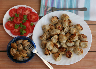 russian dumplings(pelmeni) with tomatoes and mushrooms
