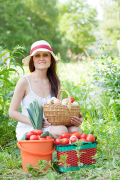 Happy woman holds vegetables harvest