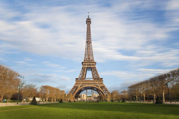 Eiffel tower with moving clouds on blue sky, Paris