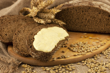 fresh bread  and rye grain on a wooden board