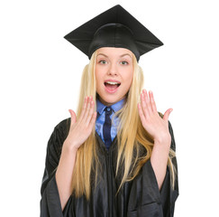 Surprised young woman in graduation gown