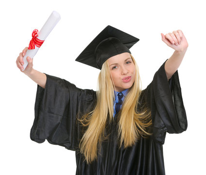 Happy woman in graduation gown with diploma rejoicing success