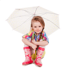 The little girl with an umbrella and in rubber boots. Isolated
