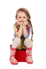 little girl sitting on the cube, isolated