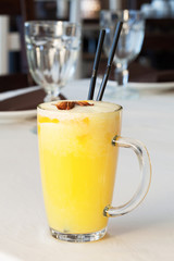 Tasty yellow cocktail with two sticks on the table.