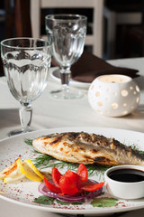 Grilled fish with tomato, herbs, onions and lemon