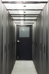 Narrow corridor sealed with telecom racks.