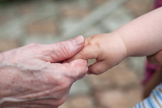 hands of baby grandson and old grandmother, concept of family re