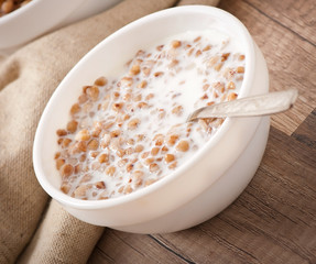 Buckwheat porridge with milk on a wooden table