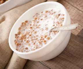 Fotobehang Buckwheat porridge with milk on a wooden table © timolina