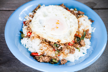 Thai spicy food, rice topped with stir fried pork and basil with