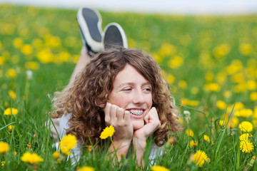 mädchen liegt entspannt auf der blumenwiese