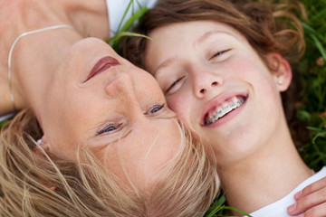 mutter und tochter liegen entspannt im gras