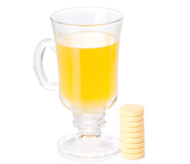 The glass of soluble vitamin C pills lying near