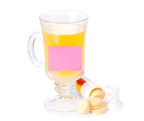 The glass of soluble vitamin C pills lying near