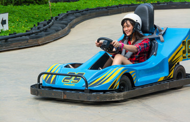 Cute Thai girl is driving Go-kart in an amusement park