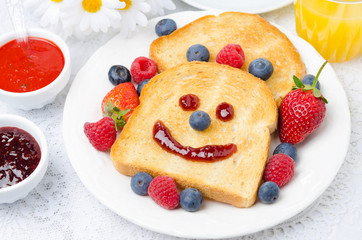 Breakfast with smiling toast, fresh berries, jams, orange juice