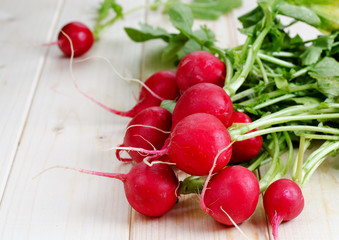 Fresh radishes from ground on old wooden table