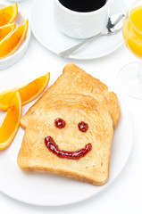 Toast with a smile of jam, orange juice, fresh oranges, coffee