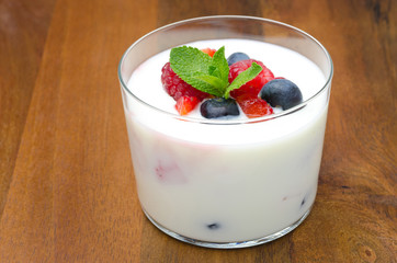 yogurt with different berries and mint in a glass beaker
