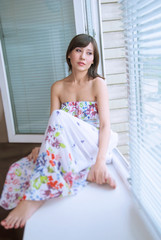 Portrait of charming girl  sitting on windowsill