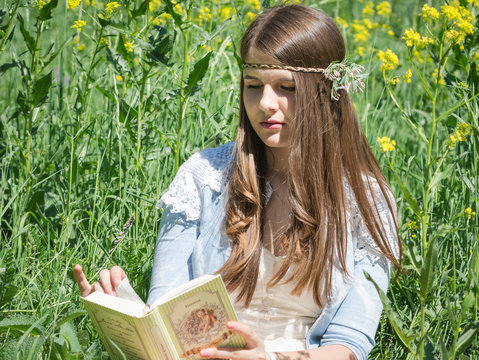 portrait of happy student relaxed outdoors reading book