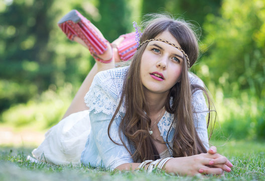 relaxed young girl sitting on grass in park