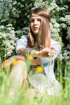 beautiful teenage girl lying on meadow of flowers