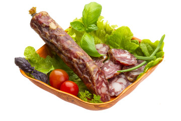 Ripe salami with salad, basil, onion and tomato