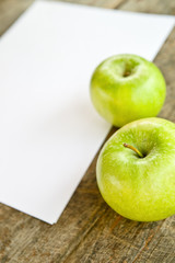Green apples and white paper