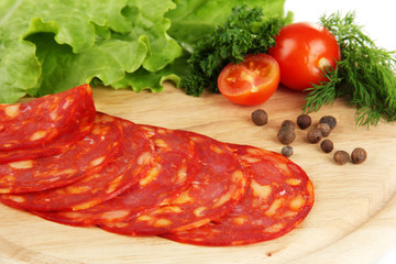 Salami slices on wooden board, close up