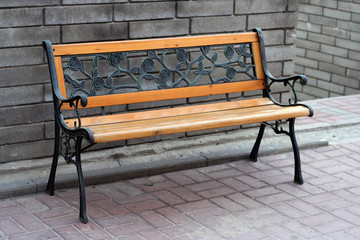 Wooden bench on the pavement road