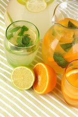 Orange and lemon lemonade in pitchers and glasses